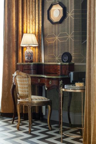 a desk with a lamp and a chair in a room at Relais & Châteaux Heritage Hotel in Madrid