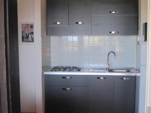 a kitchen with a sink and a stove top oven at Villetta Vista Mare Calaverde IUN Q0265 in Santa Margherita di Pula