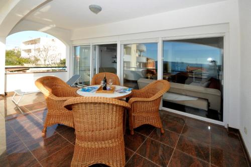 een eetkamer met rieten stoelen en een tafel bij Apartmani Svalina - Seaview and 130m from Beach in Trogir