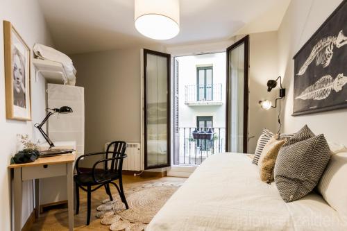 a bedroom with a bed and a desk and a window at Soul Apartmet in Pamplona
