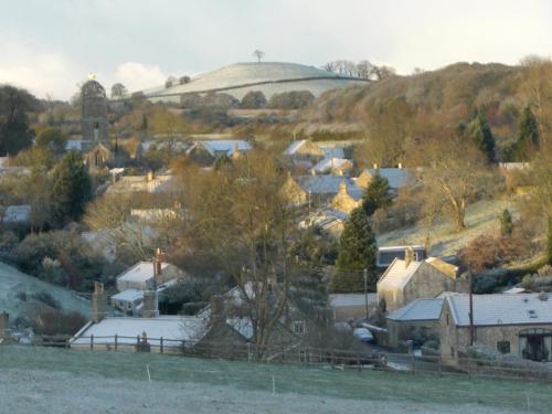 a small village with a hill in the background at Whidlecombe Farm in Priston