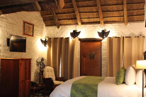 a bedroom with a bed and a fan in a room at Misty Hills Country Hotel, Conference Centre & Spa in Muldersdrift