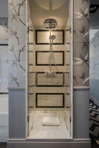 a shower with a glass door in a bathroom at Relais & Châteaux Heritage Hotel in Madrid