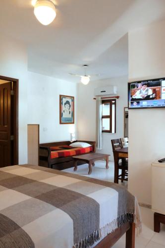 a hotel room with a bed and a flat screen tv at Hotel e Pousada La Dolce Vita in Canoa Quebrada