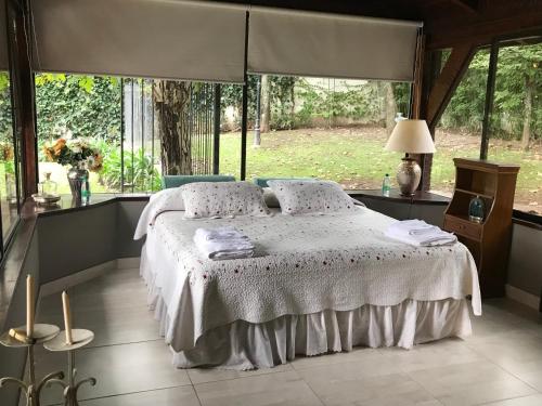 um quarto com uma cama num quarto com janelas em La Soñada em Salta