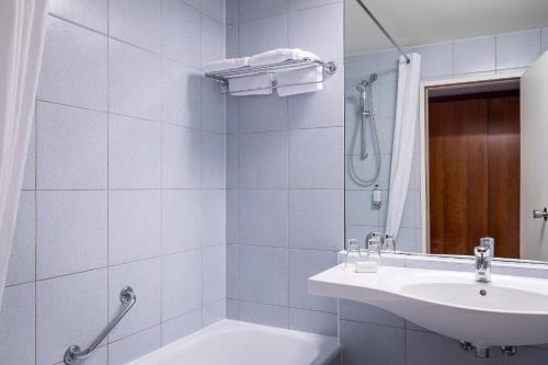 a bathroom with a shower, sink, and mirror at Astoria Hotel Antwerp in Antwerp