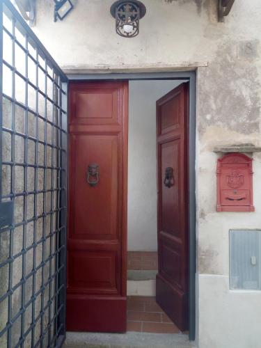 an entrance to a building with two red doors at Platea Oche in Sutri