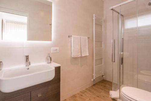 a white bathroom with a sink and a shower at Lullaby B&B in Treviso