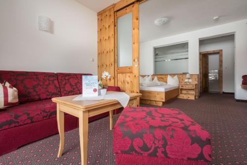 a living room with a red couch and a table at Tauferberg in Umhausen