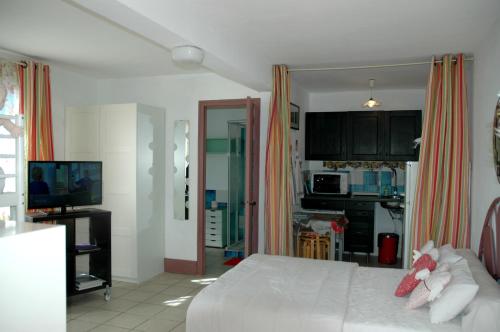 1 dormitorio con 1 cama blanca y cocina en Studios "Villa Coeur sur Mer", en La Croix-Valmer