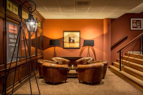 a waiting room with a leather chair and a table at Fletcher Hotel-Restaurant De Broeierd-Enschede in Enschede