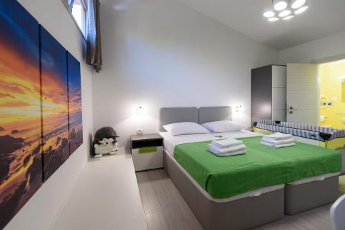 Un dormitorio con una cama con una manta verde. en Apartments Mali Stradun, en Dubrovnik