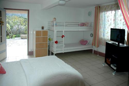 a bedroom with a white bed and a television at Studios "Villa Coeur sur Mer" in La Croix-Valmer