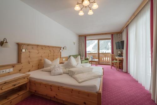 a bedroom with a large bed with a wooden headboard at Tauferberg in Umhausen