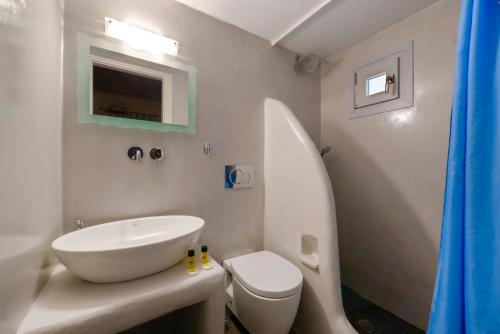 a white bathroom with a sink and a toilet at Villa Aegeon in Megalokhori