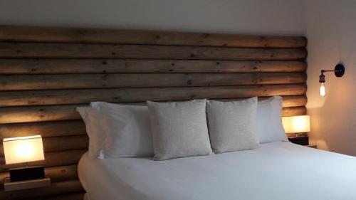 a bedroom with a wooden headboard and a bed with pillows at Hotel De La Mer in Le Barcarès