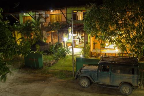 an old car parked in front of a building at night at Pousada Umbudendê in Barra Grande