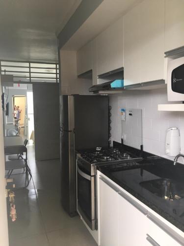 a kitchen with a stove and a stove top oven at Boulevard Center in Guarujá