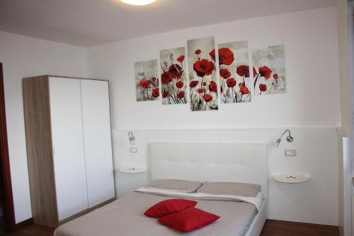 a bedroom with red poppies paintings on the wall at Ca Vecia in Gargnano