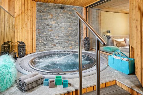 a jacuzzi tub in a room with a bed at Naturhotel Waldklause in Längenfeld