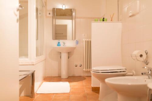 ein Badezimmer mit einem Waschbecken, einem WC und einem Spiegel in der Unterkunft Tutte le Albe nei Sassi in Matera