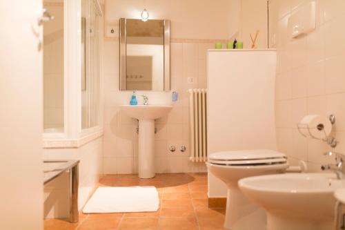 un bagno con lavandino, water e specchio di Tutte le Albe nei Sassi a Matera