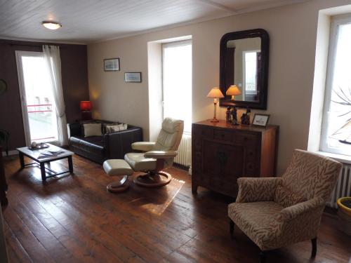 a living room with a couch and a chair and a mirror at Ty Lireu in Concarneau