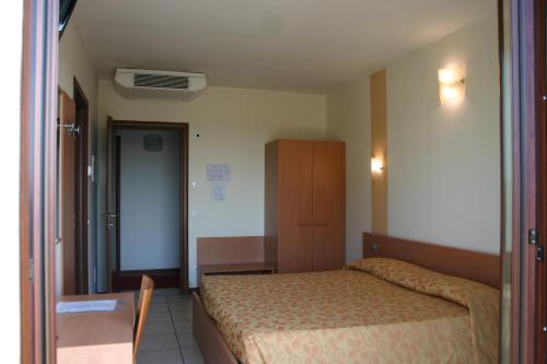 a small bedroom with a bed and a table at Hotel Moro Freoni in San Pietro in Cariano