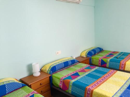 a bedroom with two beds and a table with a night stand at El Ático de Carboneras in Carboneras