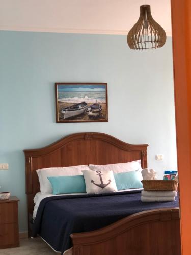 um quarto com uma cama com almofadas azuis e brancas em Casa Natali em Durrës