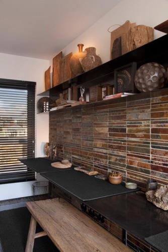 a kitchen with a table and a brick wall at Mini Loft ULB DELTA area with terrace in Brussels