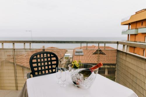 a table with glasses and a vase on a balcony at Hotel Villa Claudia in Bellaria-Igea Marina