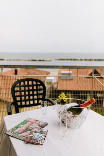 a table with a bowl of meat and a glass of wine at Hotel Villa Claudia in Bellaria-Igea Marina