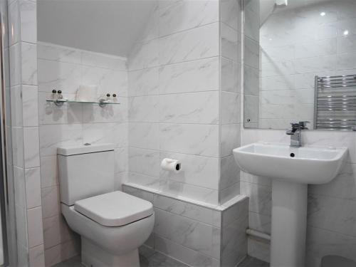 a white bathroom with a toilet and a sink at The Limes Country Lodge Hotel & Admiral Restaurant in Solihull