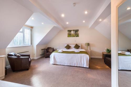 a attic room with a bed and a chair at The Limes Country Lodge Hotel & Admiral Restaurant in Solihull