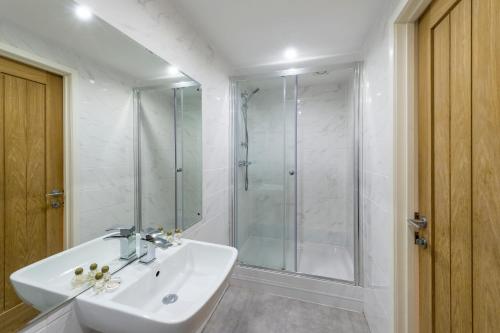 a bathroom with a white sink and a shower at The Limes Country Lodge Hotel & Admiral Restaurant in Solihull