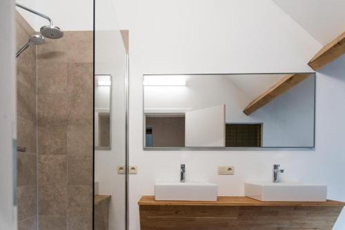 een badkamer met 2 wastafels en een spiegel bij Constantinus in Herzele