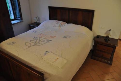 a bedroom with a bed and a nightstand with a bed sidx sidx at Farmstay Agriturismo La Fonte in Belforte del Chienti