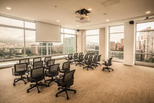 a conference room with chairs and a projection screen at V Grand Hotel, a member of Radisson Individuals in Medellín