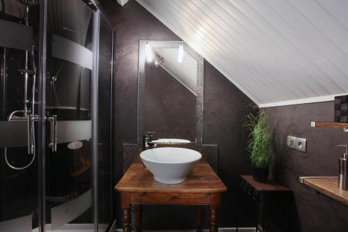 ein Bad mit einem Waschbecken und einer Glasdusche in der Unterkunft Cosy Cottage in Bourbourg