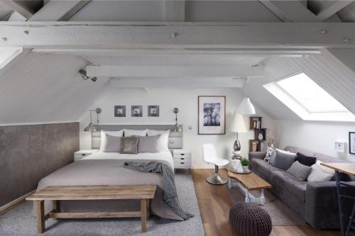 ein Schlafzimmer mit einem großen Bett und einem Sofa in der Unterkunft Cosy Cottage in Bourbourg