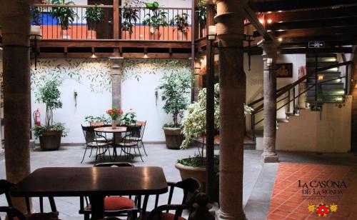 a patio with tables and chairs and plants in a building at La Casona de la Ronda Hotel Boutique in Quito