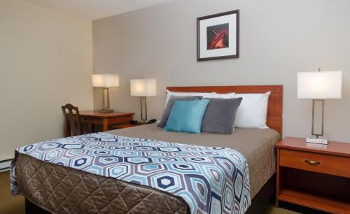 - une chambre avec un lit, 2 tables de nuit et 2 lampes dans l'établissement Coastal Inn Moncton/ Dieppe, à Moncton