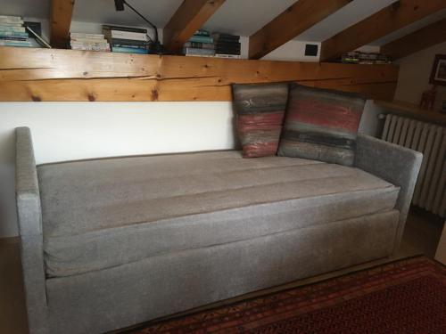 a grey couch in a room with a wooden wall at Suite Ananda in Verbania