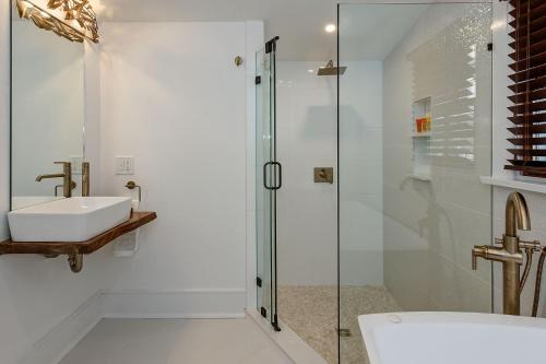 uma casa de banho com uma cabina de duche em vidro e um lavatório. em Casablanca em Cape May