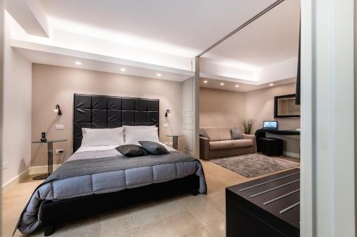 1 dormitorio con 1 cama grande y 1 silla en Hotel Porta Reale, en Noto