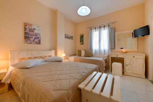 a bedroom with two beds and a television in it at Villa Aegeon in Megalokhori