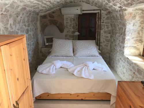 a bedroom with a bed with towels on it at Villa Amalia in Halki