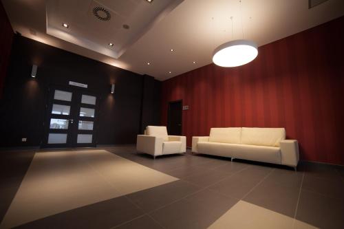 two white couches in a room with a red wall at Brea's Hotel in Reus