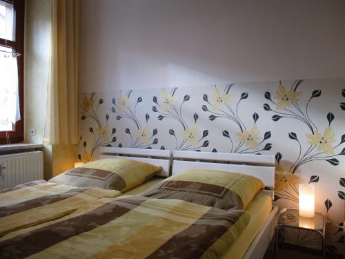 a bedroom with a bed and a wall with flowers at Ferienwohnung Alte Apotheke in Eibenstock